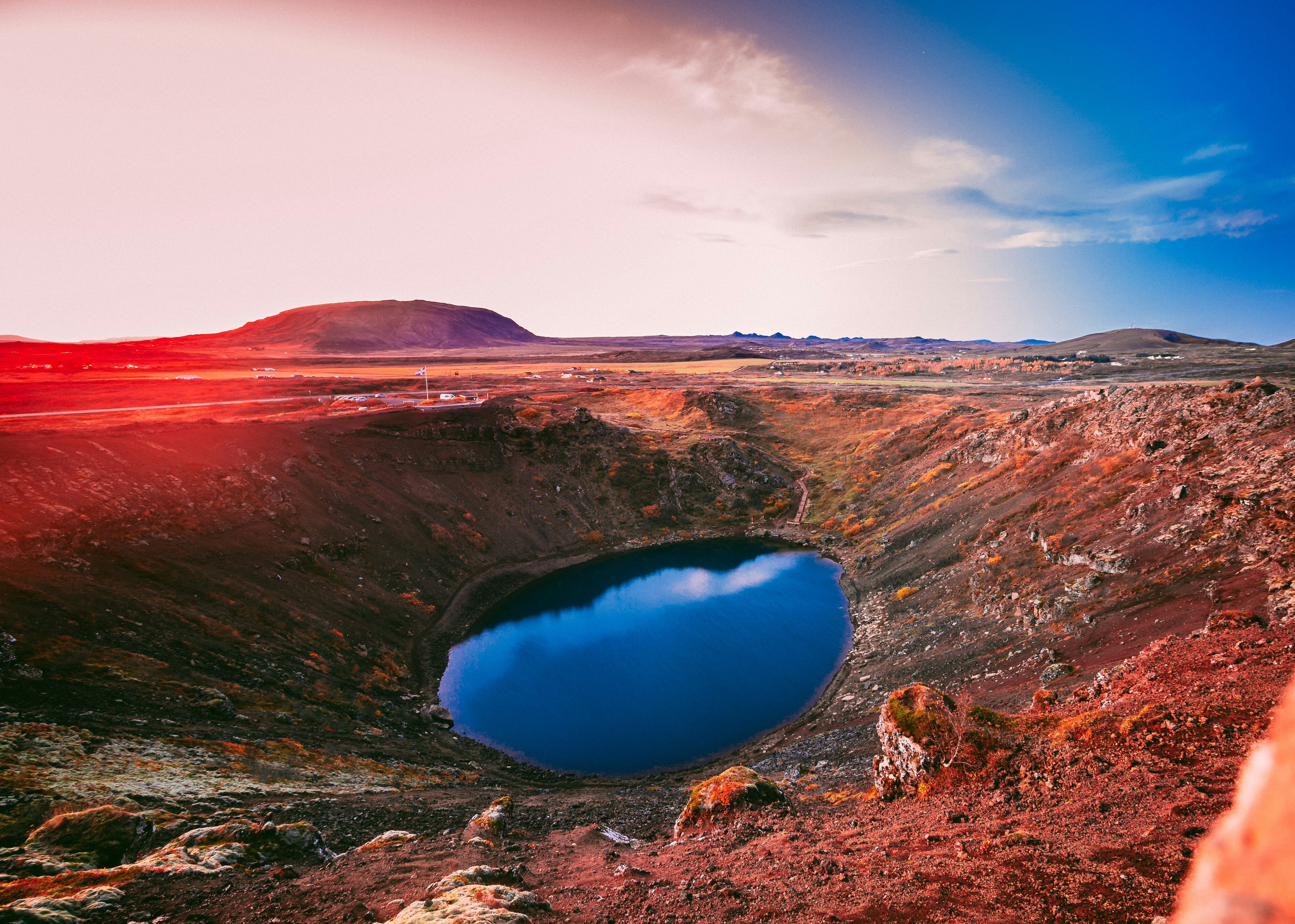 blue lake in the middle of brown mountains